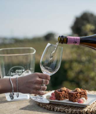Persona servint vi blanc del Penedès en una copa en un tast de vins amb maridatge