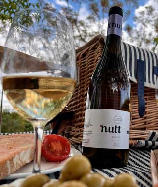 Copa de vi blanc amb ampolla Nutt en un tast de vins amb maridatge al Penedès